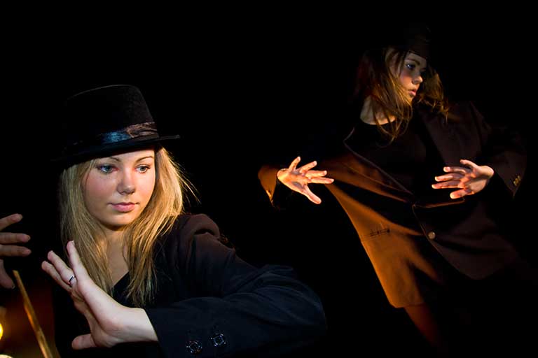 Dans med udtryk To piger danser i sort herretøj