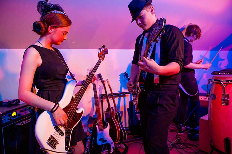 Musikelever spiller med i forestilling Elever spiller musik på elguitar til forestilling