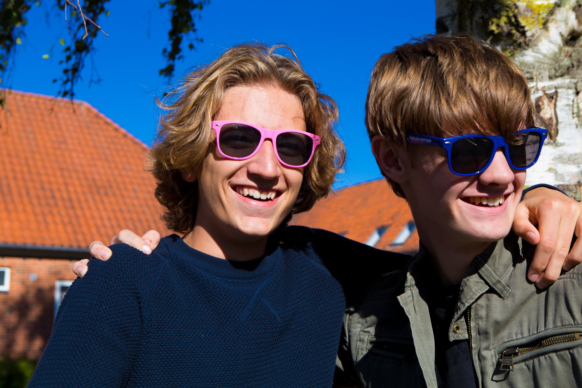 Venner med solbriller To smilende drenge med solbriller